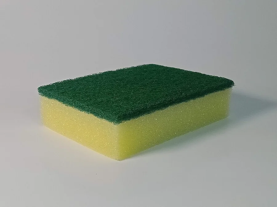 A green and yellow cleaning sponge